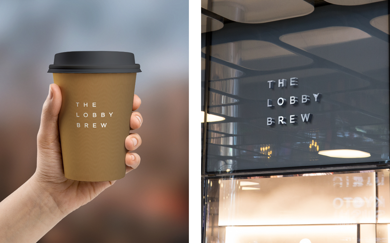 The Lobby Brew takeaway cup held in hand beside the storefront signage