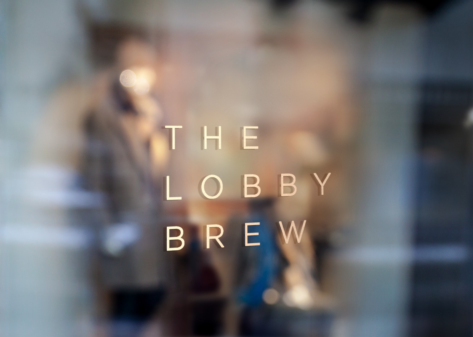The Lobby Brew wordmark in gold on a café window